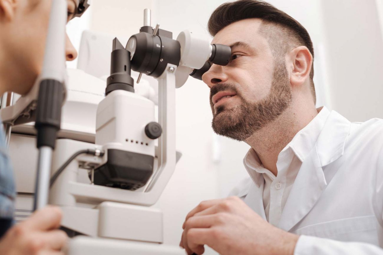 medico oculista intento a visitare un paziente